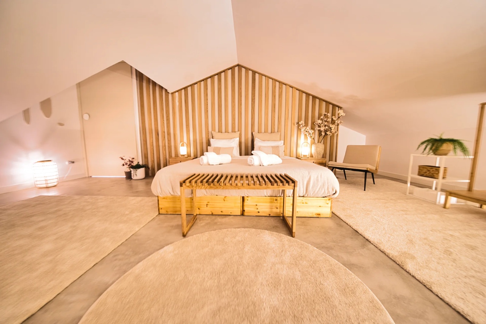Slaapkamer onder het dak met houten lamellenwand